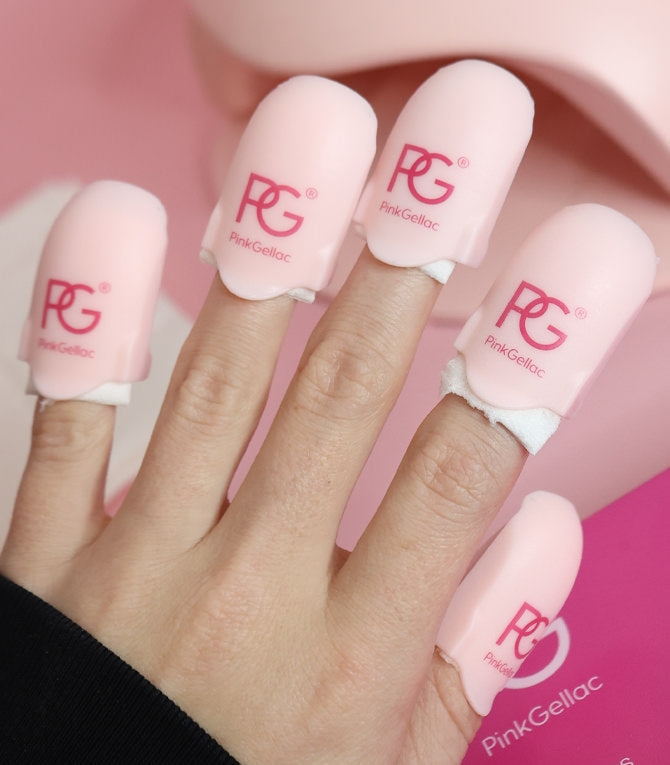 A hand with four fingers covered with pink nail polish remover caps from Pink Gellac, on a pink background.