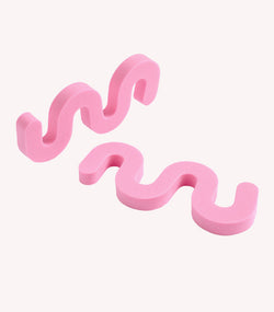 Two pink, wavy foam pieces on a white background.