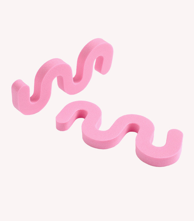 Two pink, wavy foam pieces on a white background.