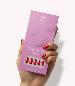 Hand holding Pink Gellac 109 Lipstick Red press-on nails in their packaging.