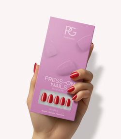 Hand holding Pink Gellac 109 Lipstick Red press-on nails in their packaging.