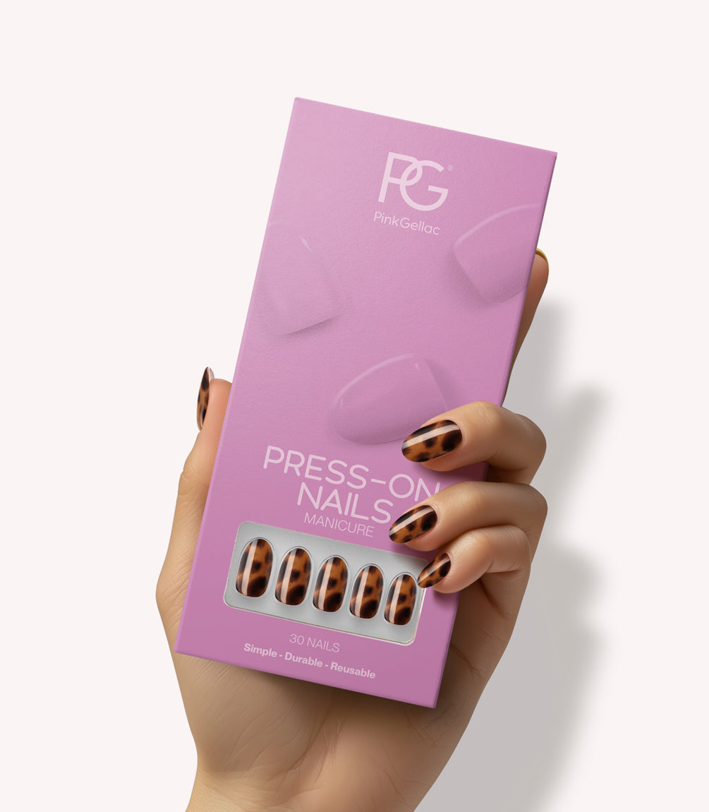 Hand holding Pink Gellac 2007 Tortoise Touch press-on nails in their packaging.
