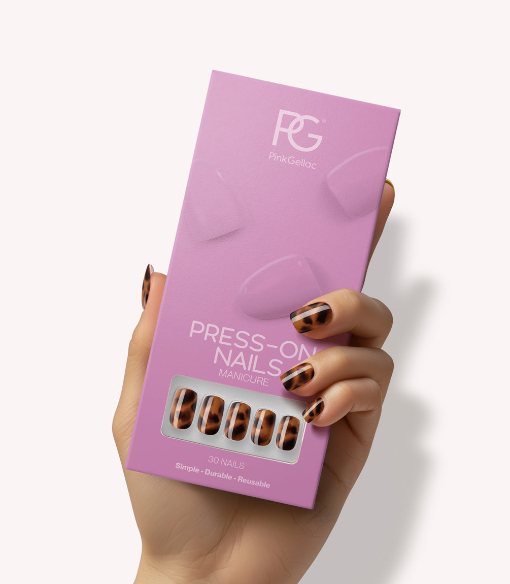 Hand holding Pink Gellac 2007 Tortoise Touch press-on nails in their packaging.