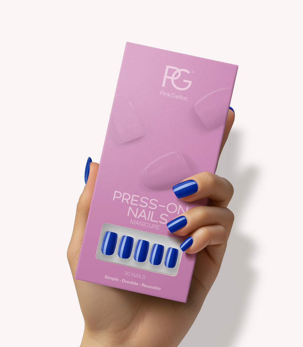 Hand holding Pink Gellac 221 Delighted Blue press-on nails in their packaging.