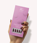 Hand holding Pink Gellac 332 Sangria Red press-on nails in their packaging.