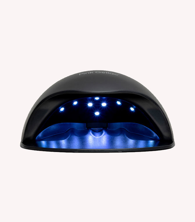 Black UV/LED nail lamp with blue lights inside, used for curing gel nail polish.