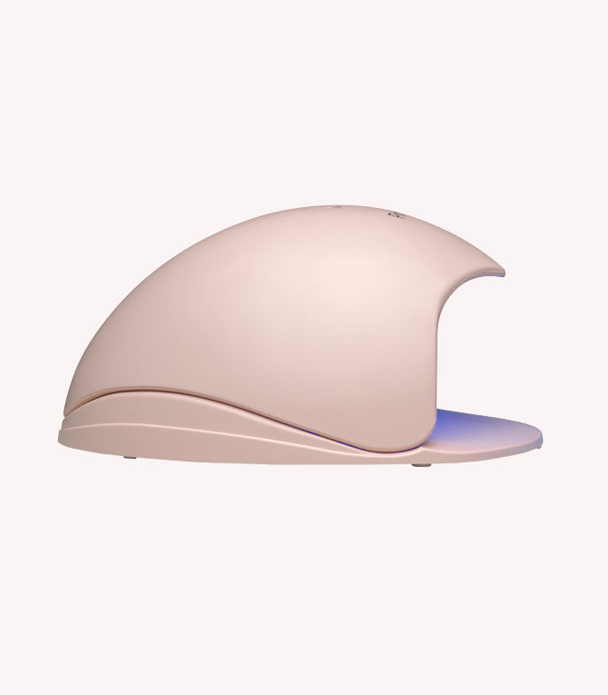Pink portable artificial nail lamp with curved design and blue lighting.