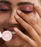 Smiling person with pink eyeshadow and light nail polish holds her hand in front of the face, with the text "Applied on 105 Blush Orange" on the image.