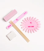 Nail care kit that includes a pink nail file, pink polishing block, wooden sticks, and a pink nail sample that reads "DARE TO SHINE."