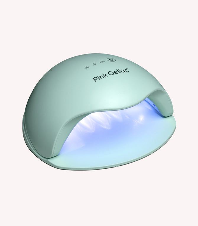 Mint green LED nail lamp with brand name "Pink Gellac" on the top and a soft blue glow on the inside.