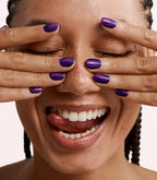 Close-up of a woman with Pink Gellac Cat Eye Divine Quartz manicured nails near her face.