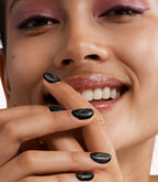 Close-up of a woman with Pink Gellac Cat Eye Starlit Silver manicured nails near her face.
