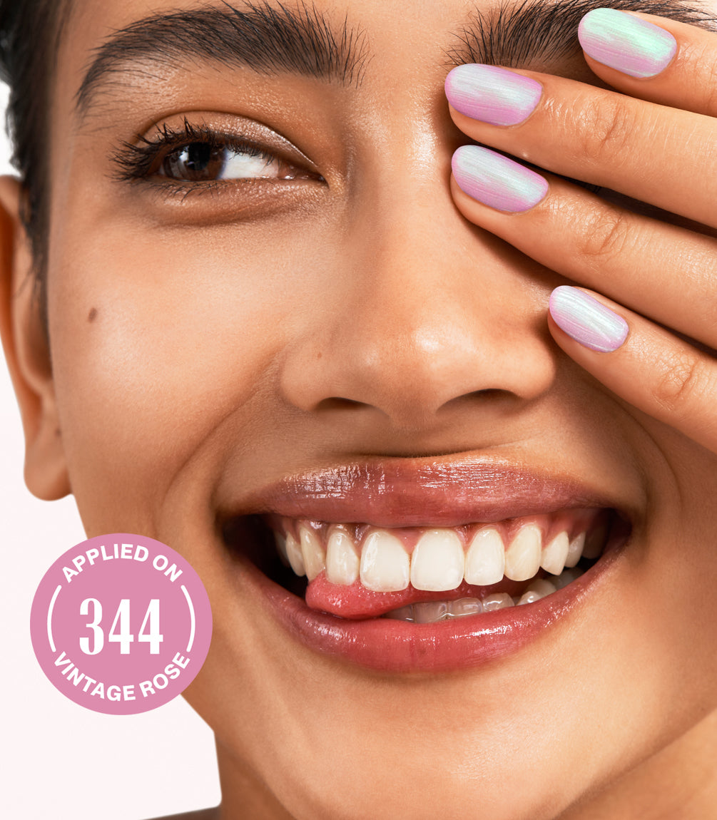 Close-up of a woman with Pink Gellac Effect Coat Celestial Green manicured nails near her face.