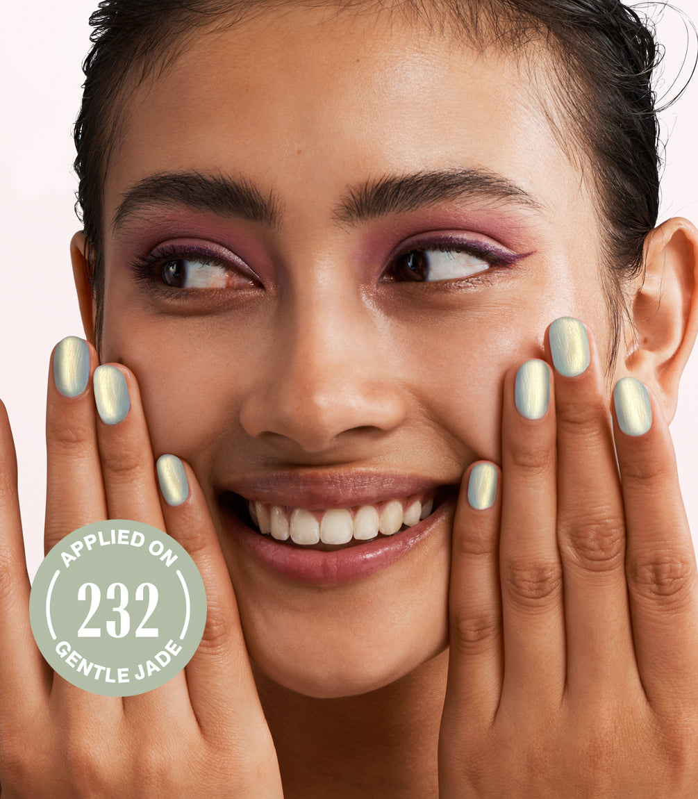 Close-up of a woman with Pink Gellac Effect Coat Glowing Gold manicured nails near her face.