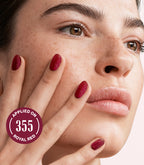 Close-up of a woman with Pink Gellac Effect Coat Gold Glitter manicured nails near her face.