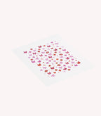 A sheet of small stickers in pink and red tones, with shapes such as hearts, butterflies, flowers and bows.