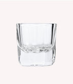 Transparent, thick-walled glass with a square shape on a light background.