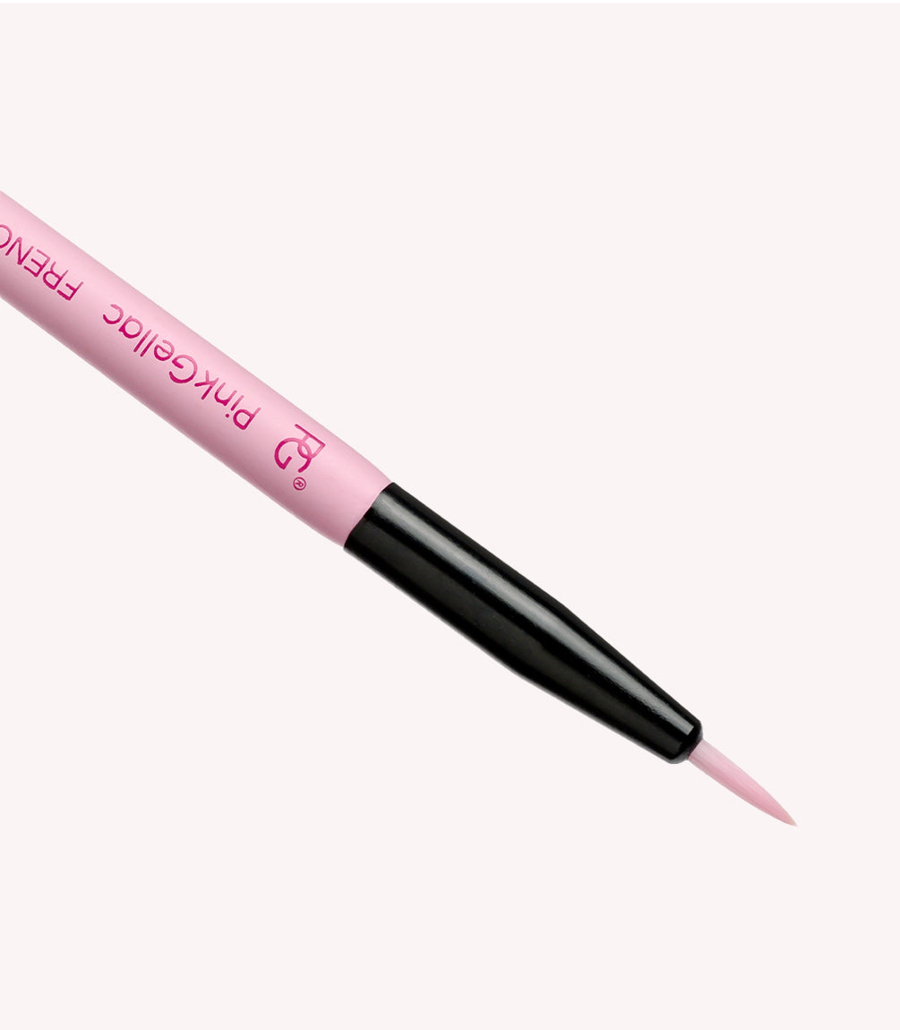 Pink artist's brush with black handle on a light background.