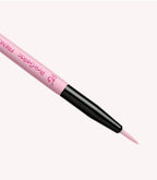 Pink artist's brush with black handle on a light background.