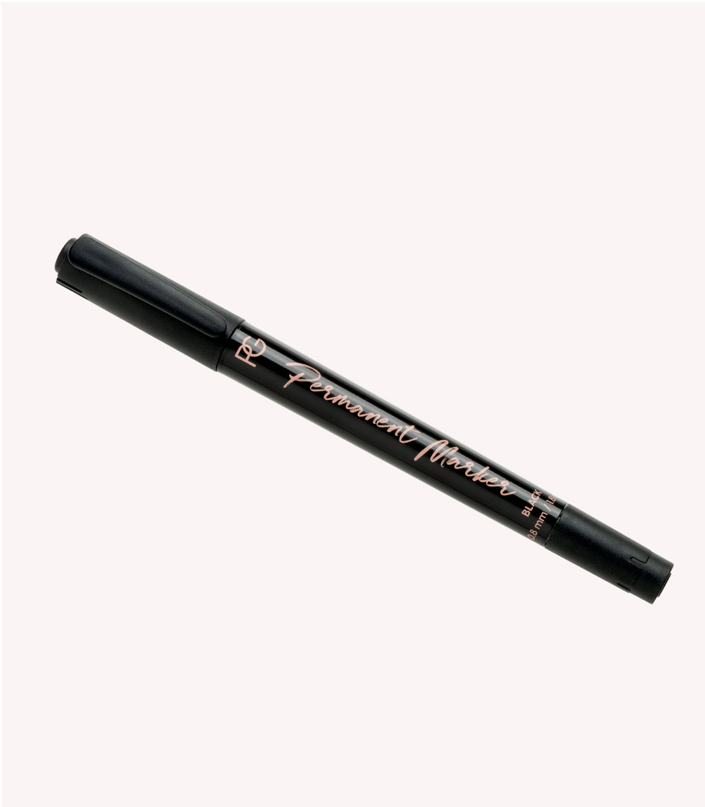 Black permanent marker with pink print on a white background.