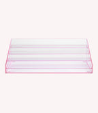 A clear, pink nail polish display stand with multiple vertical compartments.
