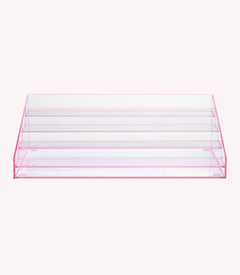 A clear, pink nail polish display stand with multiple vertical compartments.